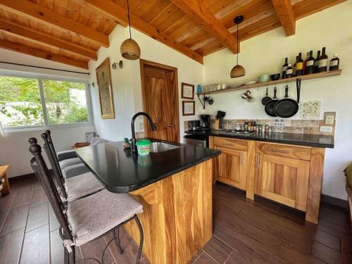 a kitchen with a black counter top and wooden cabinets at Refugio del Volcan Casitas in San Pedro La Laguna