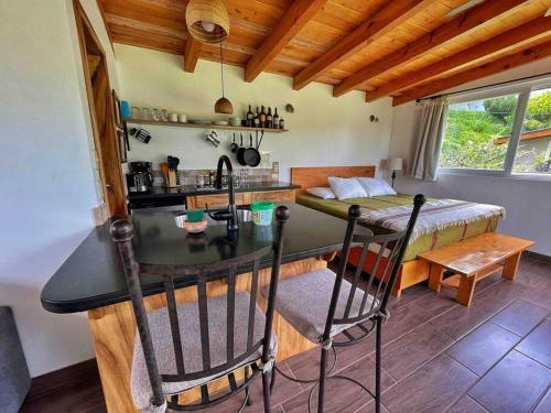 a kitchen with a counter and a table in a room at Refugio del Volcan Casitas in San Pedro La Laguna