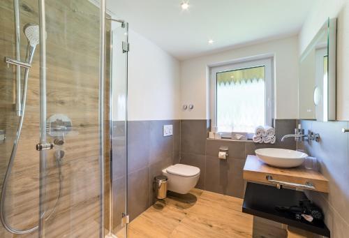 a bathroom with a shower and a toilet and a sink at Bergzeit - Hotel & Appartements in Oberjoch