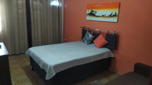 um quarto com uma cama com uma parede laranja em Arraial do Cabo - Suite luxo em Arraial do Cabo