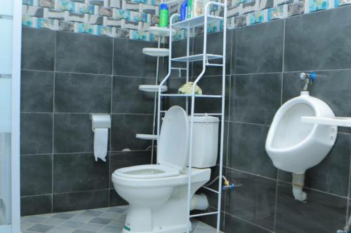 ein Bad mit WC und Urinal in der Unterkunft Gipir & Labango Ventures in Entebbe