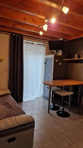 Cette chambre comprend une table, un lit et une cuisine. dans l'établissement gites 2 beauvoir, à Beauvoir