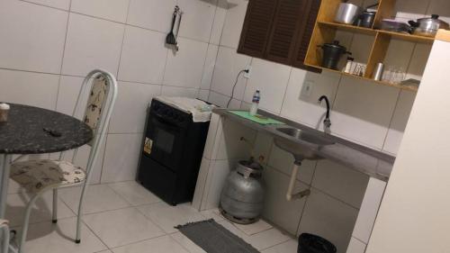 cocina pequeña con fregadero y nevera pequeña en Kitnet para 5 pessoas com cozinha perto do aeroporto en Natal