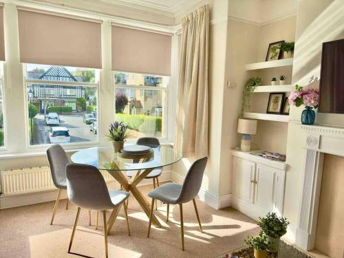 a dining room with a table and chairs and a window at Spacious & Bright 3 bed Harrogate Apartment in Harrogate