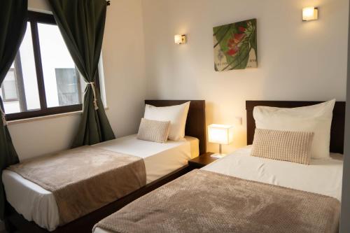 a bedroom with two beds and a window at Casa Cubada in Santa Maria