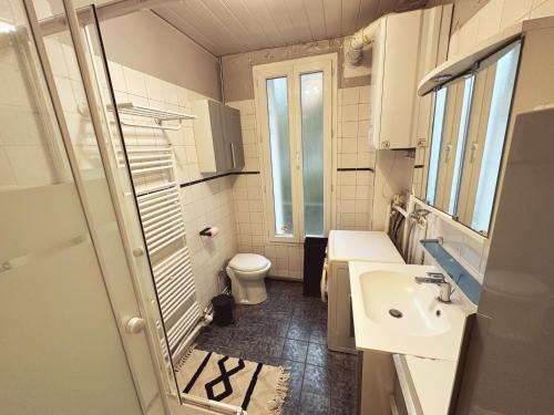 La petite salle de bains est pourvue d'un lavabo et de toilettes. dans l'établissement La Suite - Charmant duplex proche Paris, à Villejuif