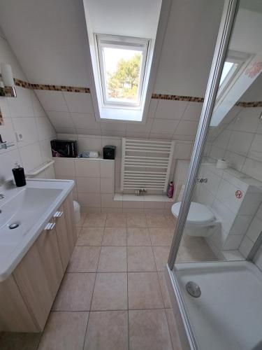 a bathroom with a shower and a sink and a toilet at Nei Stich 19a Wohnung 1 in Norddorf