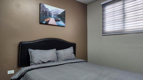 1 dormitorio con 1 cama y una foto en la pared en The Layover - 6 mins from the airport, Fully equipped for short and long stays en Kelly Village