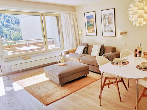 een woonkamer met een bank en een tafel bij Sankt Moritz Spirit Piz San Gian 14 in St. Moritz