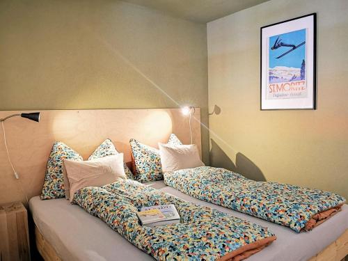 een slaapkamer met 2 bedden met kussens erop bij Sankt Moritz Spirit Piz San Gian 14 in St. Moritz