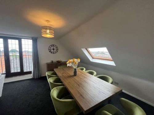 a conference room with a wooden table and green chairs at BS - Luxury top floor 4 bed apartment with garage in town centre - NO LIFT in Stratford-upon-Avon