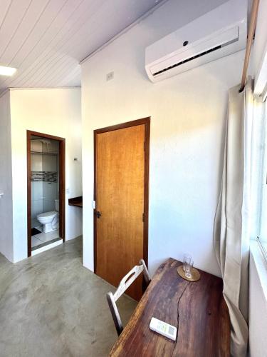 a room with a wooden table and a toilet at Pousada/Camping Mirante Serrano in Alto Paraíso de Goiás