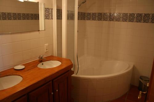 W łazience znajduje się umywalka i wanna. w obiekcie La Bergerie w mieście Beaulieu-sur-Dordogne