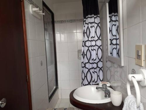 a white bathroom with a sink and a shower at Apto frente al mar en La paloma in La Paloma