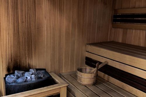 a small wooden sauna with a bucket and logs at Lola apartman Milmari & Residence Hill in Kopaonik