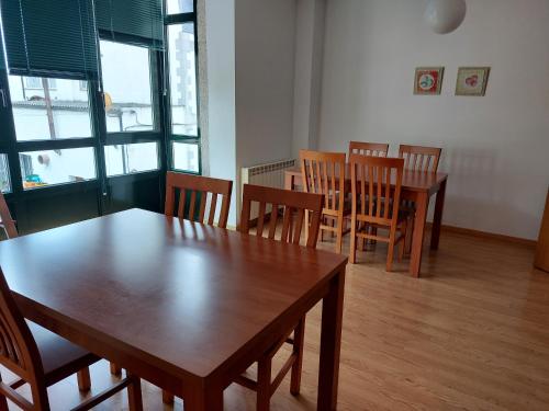 uma sala de jantar com mesas e cadeiras de madeira em Hospedería Externa del Monasterio em Samos