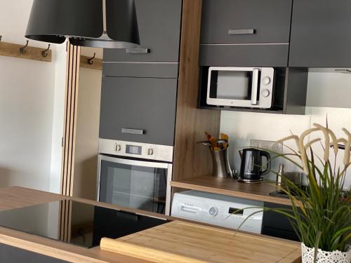 une cuisine avec une cuisinière et un micro-ondes dans l'établissement La Kaz montagne, à Briançon