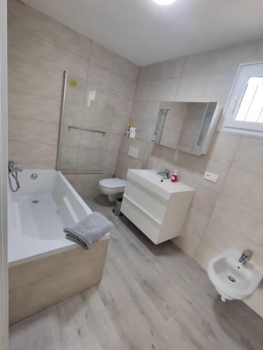 une salle de bain avec une baignoire, des toilettes et un lavabo dans l'établissement La perle de Sète Maison bord de l étang Animaux bienvenus Sur demande, à Sète