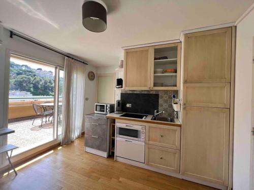 une cuisine avec un évier et une cuisinière dans l'établissement La Rose des Vents Bord de mer, à Roquebrune-Cap-Martin