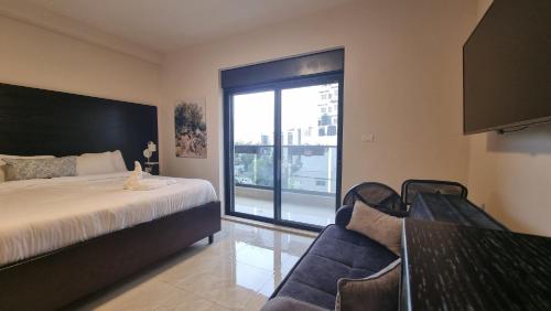 a bedroom with a bed and a large window at Mizirawi Historic Hotel in Ramallah