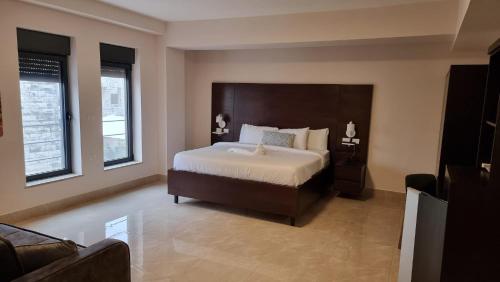 a bedroom with a large bed and a couch at Mizirawi Historic Hotel in Ramallah