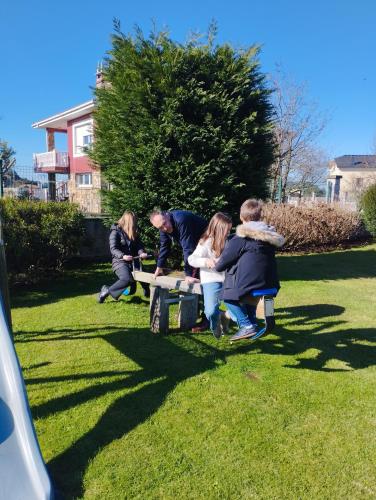 a group of people sitting on a park bench at Apartamentos La Cruz de Paderne in Navia