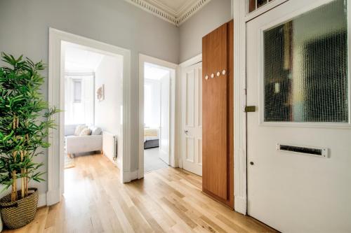 a hallway with a door and a living room at Two Bed Stylish Apartment in Heart of West End in Glasgow
