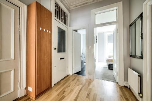 a room with a hallway with wooden floors and a door at Two Bed Stylish Apartment in Heart of West End in Glasgow