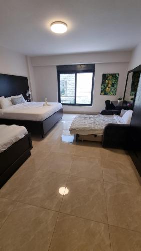 a large room with two beds and a couch at Mizirawi Historic Hotel in Ramallah