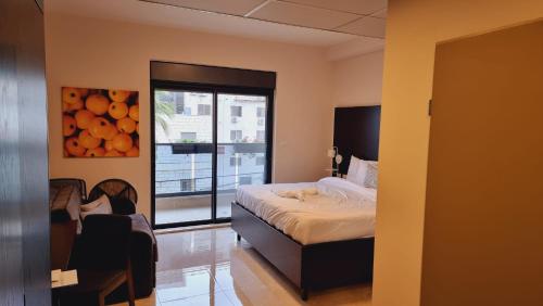 a bedroom with a bed and a large window at Mizirawi Historic Hotel in Ramallah