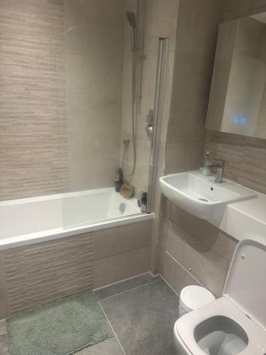 a bathroom with a sink and a toilet and a bath tub at Flat beckenham road in Beckenham