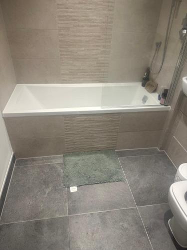 a bathroom with a bath tub and a toilet at Flat beckenham road in Beckenham