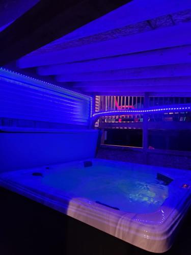 a large tub in a room with blue lights at Havre de détente avec foyer et spa in Sainte-Lucie-de-Doncaster