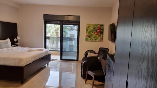 a bedroom with a bed and a sliding glass door at Mizirawi Historic Hotel in Ramallah