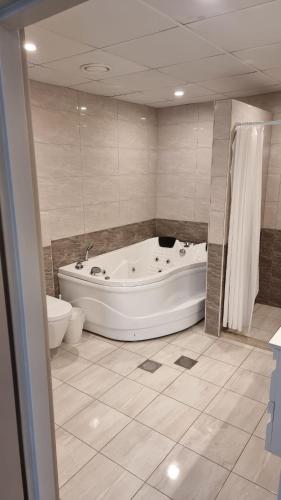 a bathroom with a tub and a toilet and a bath tub at Mizirawi Historic Hotel in Ramallah