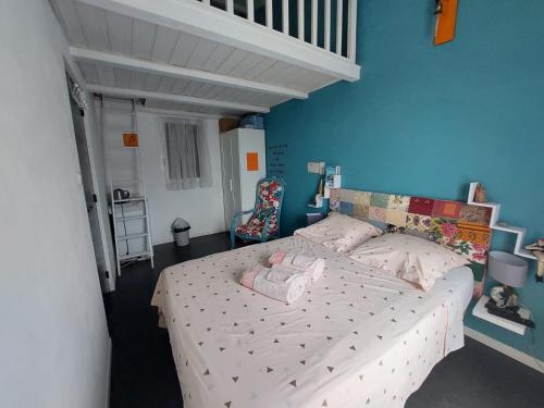 une chambre avec un lit et un mur bleu dans l'établissement LOUTHEPIECLA, à Bendéjun