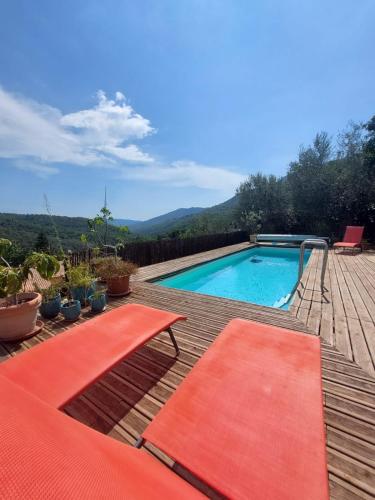 a swimming pool with orange cushions on a deck at LOUTHEPIECLA in Bendéjun