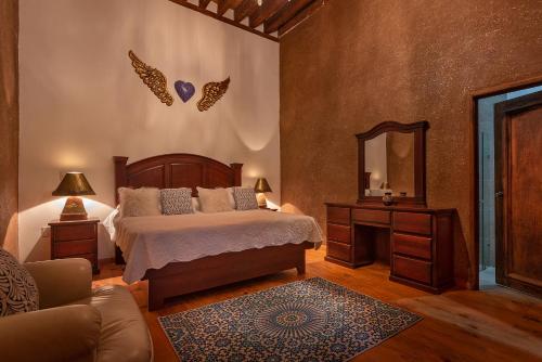 Schlafzimmer mit einem Bett und einem Spiegel in der Unterkunft HOTEL LA CASA DE DON VASCO in Pátzcuaro