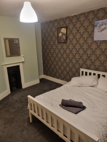 a bedroom with a white bed with a fireplace at Maidstone castle 3bedroom free sports channels, parking in Kent