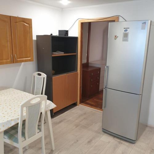a kitchen with a refrigerator and a table and chairs at Дом in Oral