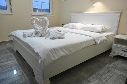dois cisnes brancos sentados em cima de uma cama em Smeštaj TEA em Vrnjačka Banja