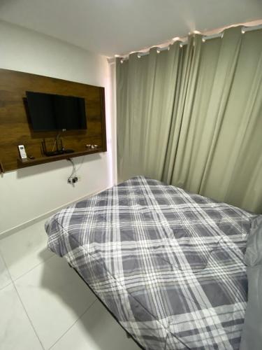 Flat Siberian 100m do mar في كابيديلو: غرفة نوم مع سرير ونافذة مع تلفزيون