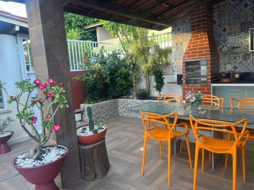 eine Terrasse mit einem Tisch, Stühlen und Pflanzen in der Unterkunft Casa em Condomínio, Piscina Privativa e Área Gourmet in Camaçari