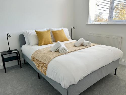 a bedroom with a large white bed with yellow pillows at The Town House, whole house suitable for contractors and families in Market Harborough
