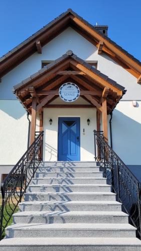 schody prowadzące do budynku z niebieskimi drzwiami w obiekcie Górskie Przysiółki w Koniakowie - Dom z Widokiem Szańce w mieście Koniaków
