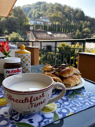 una taza de café y un plato de repostería en una mesa en Luxury Apartment Vanacore, en Castelnuovo Cilento