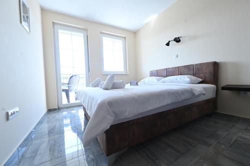 a bedroom with a large bed with a wooden headboard at Smeštaj TEA sa dva bazena i besplatan parking in Vrnjačka Banja