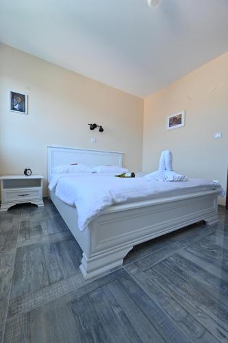 a bedroom with a large white bed in a room at Smeštaj TEA sa dva bazena i besplatan parking in Vrnjačka Banja