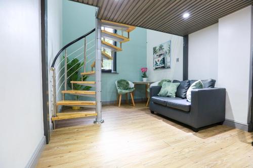 salon ze schodami i kanapą w obiekcie B102 Modern City Loft w Coventry
