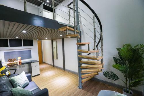 salon z łóżkiem na podwyższeniu i spiralnymi schodami w obiekcie B102 Modern City Loft w Coventry